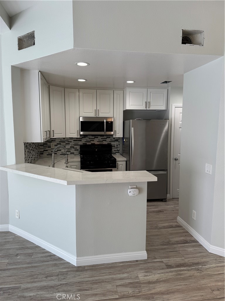 1730 Sinaloa Road Simi Valley, CA 93065 - Photo 9 of 38 a kitchen with stainless steel appliances a refrigerator stove microwave and cabinets