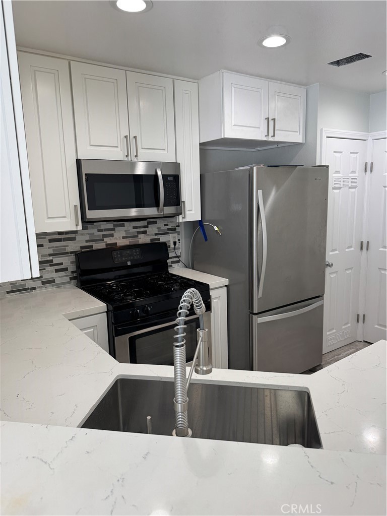 1730 Sinaloa Road Simi Valley, CA 93065 - Photo 10 of 38 a kitchen with granite countertop a refrigerator and a stove top oven