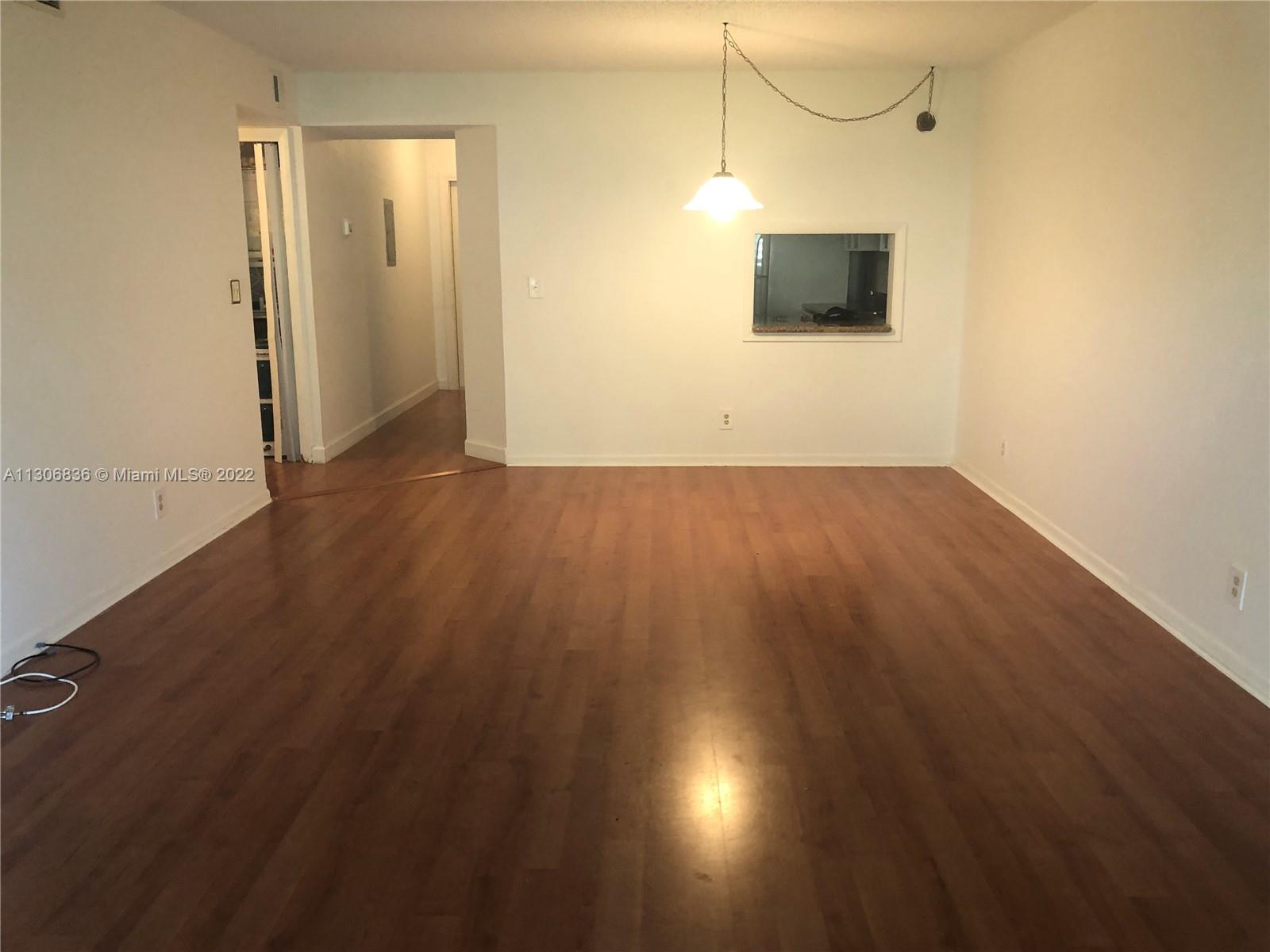 250 Gate Road, Unit 153 Hollywood, FL 33024 - Photo 19 of 19 an empty room with wooden floor and windows