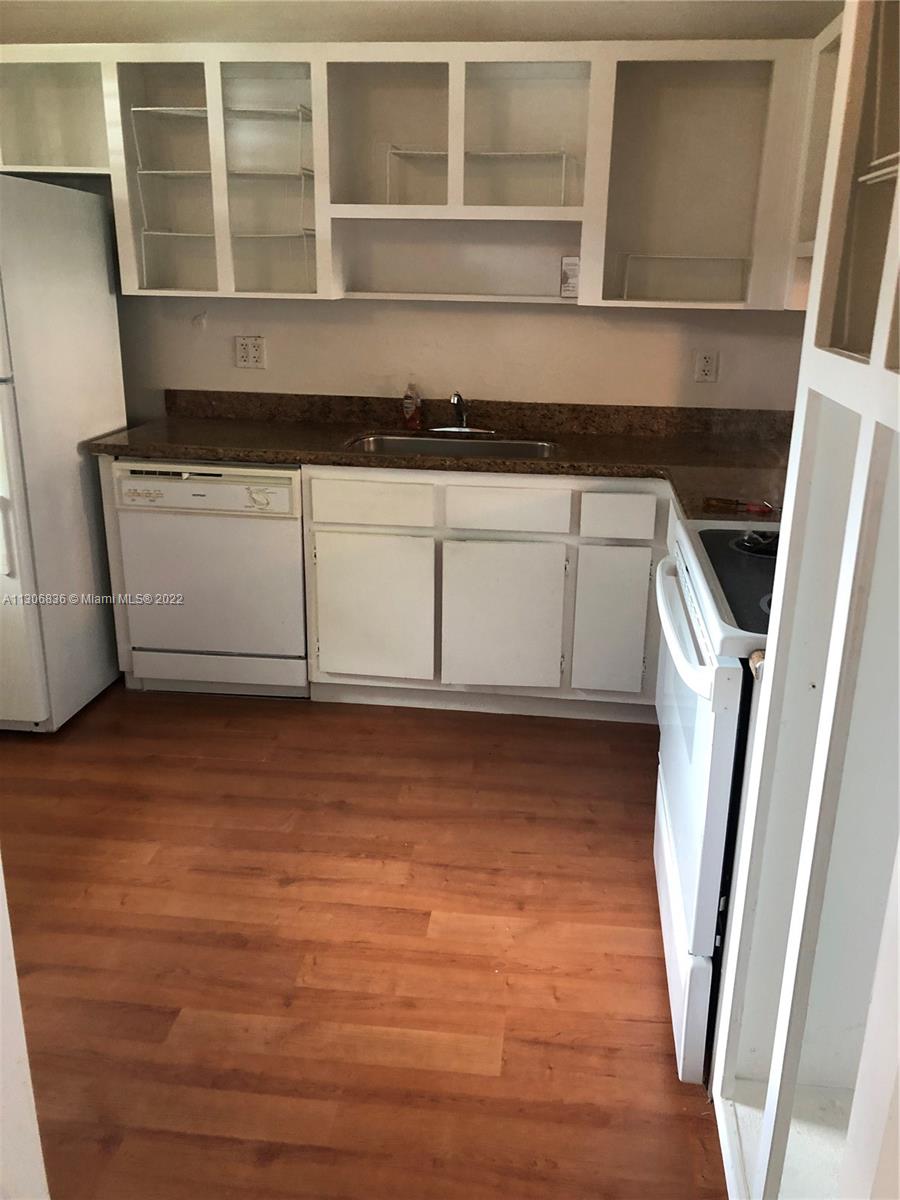 250 Gate Road, Unit 153 Hollywood, FL 33024 - Photo 4 of 19 a kitchen with a sink and a wooden floor