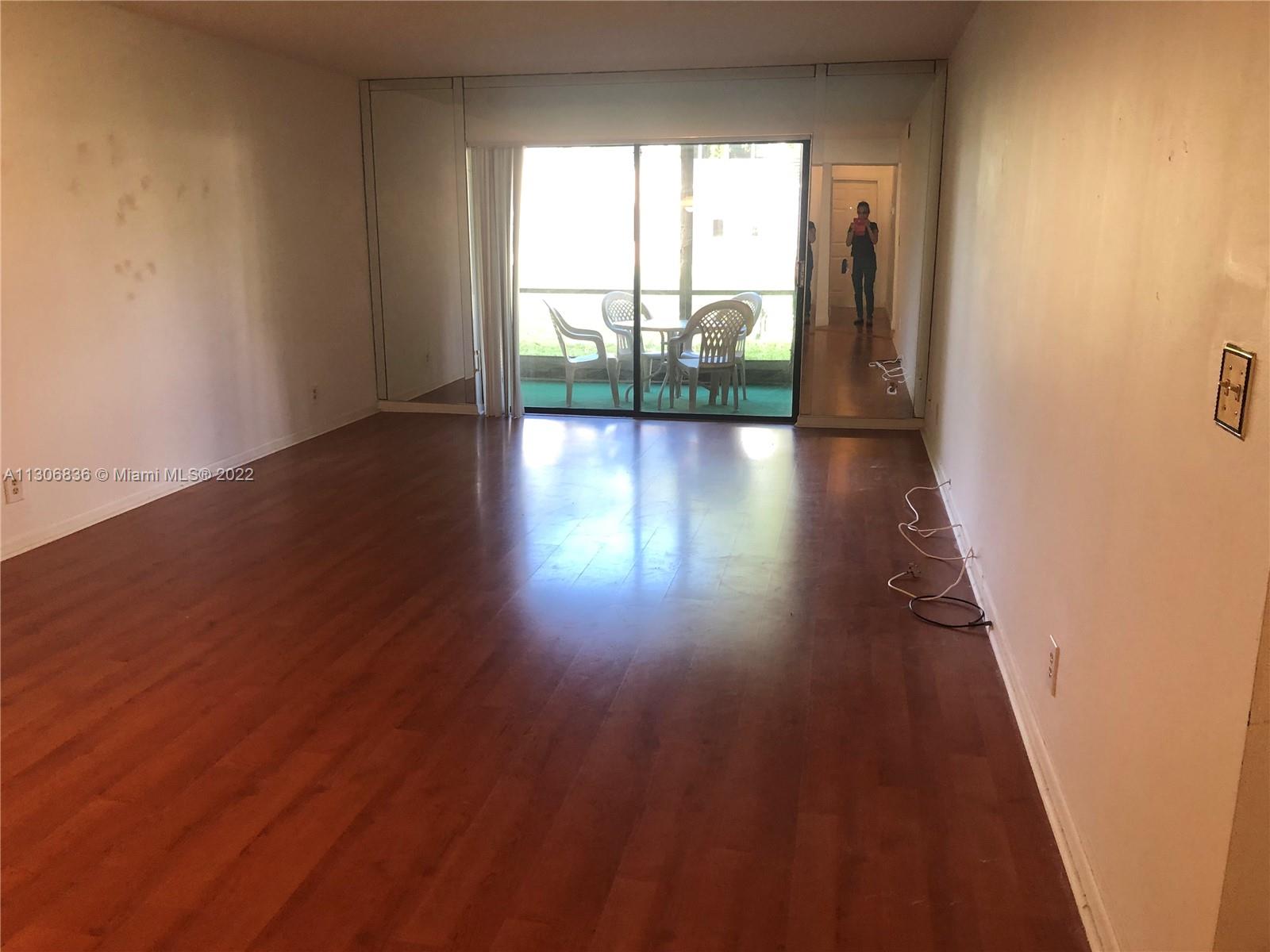 250 Gate Road, Unit 153 Hollywood, FL 33024 - Photo 7 of 19 wooden floor in an empty room with a window