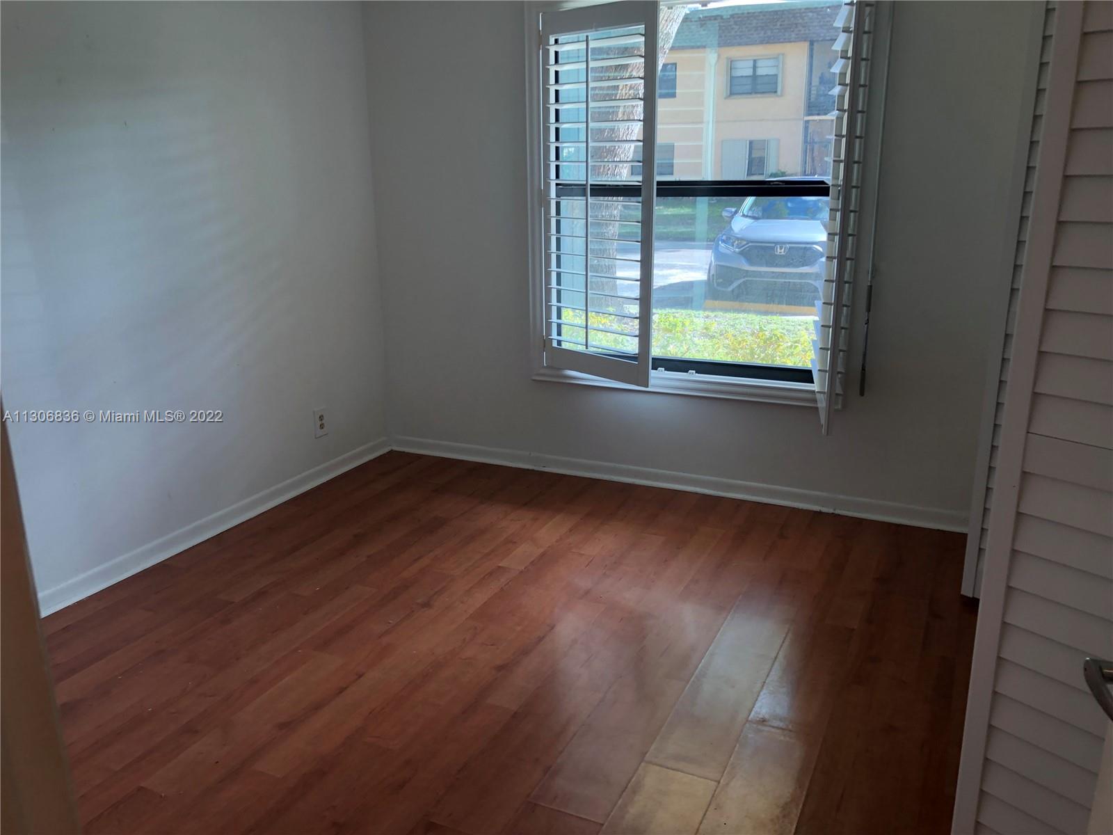 250 Gate Road, Unit 153 Hollywood, FL 33024 - Photo 9 of 19 an empty room with wooden floor and windows