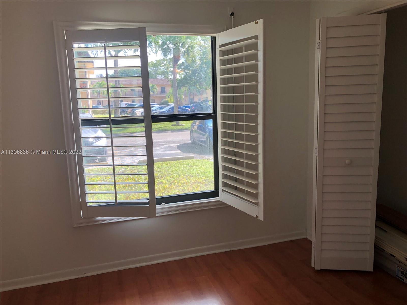 250 Gate Road, Unit 153 Hollywood, FL 33024 - Photo 10 of 19 a view of an empty room with a window and wooden floor