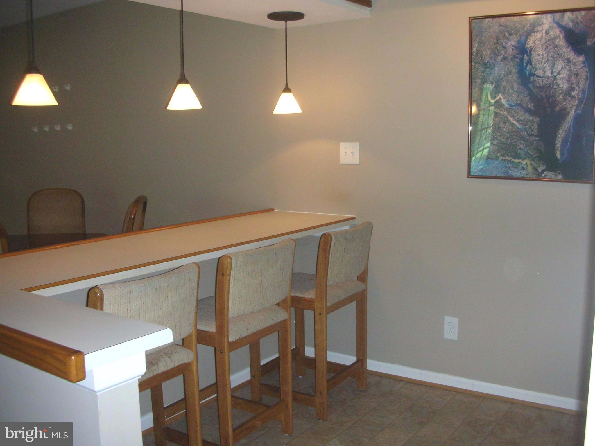 8312 Kingsgate Road, Unit 535 Springfield, VA 22152 - Photo 4 of 19 Kitchen with Breakfast Bar and Tier Lighting