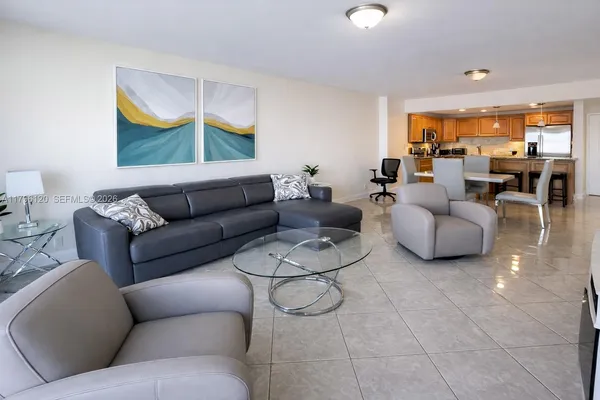a living room with furniture and kitchen view