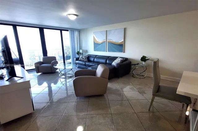 a living room with furniture and large windows