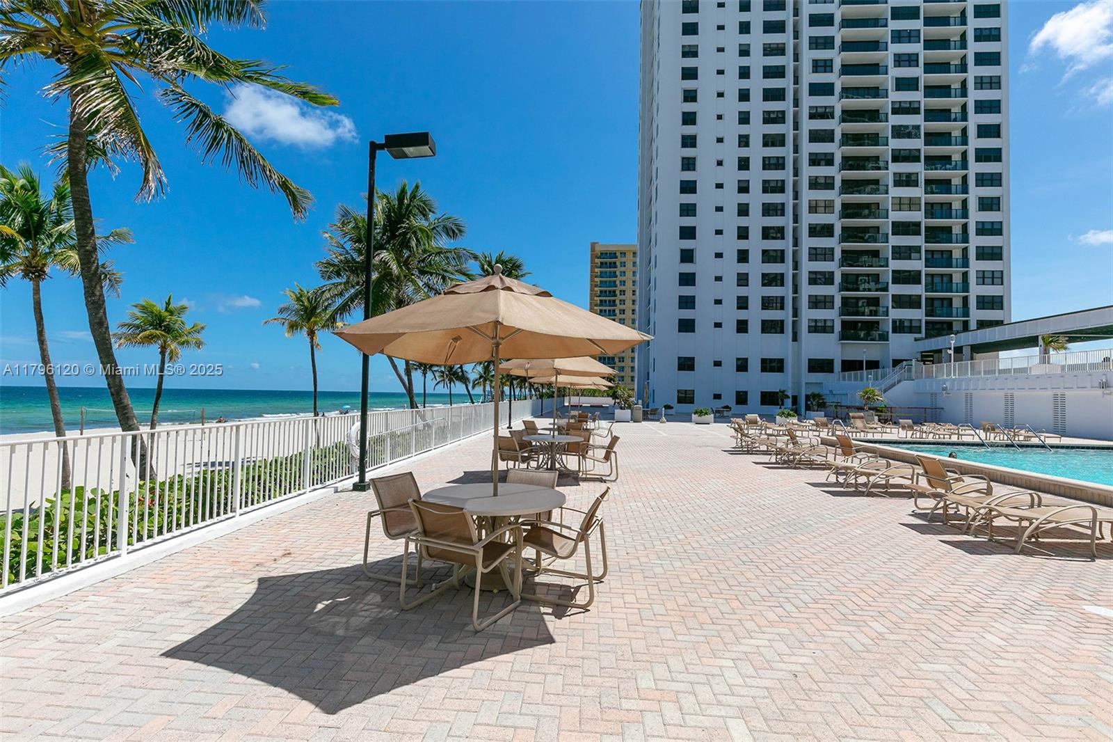 2101 South Ocean Drive, Unit 606 Hollywood, FL 33019 - Photo 27 of 58 a view of a patio with a table and chairs under an umbrella