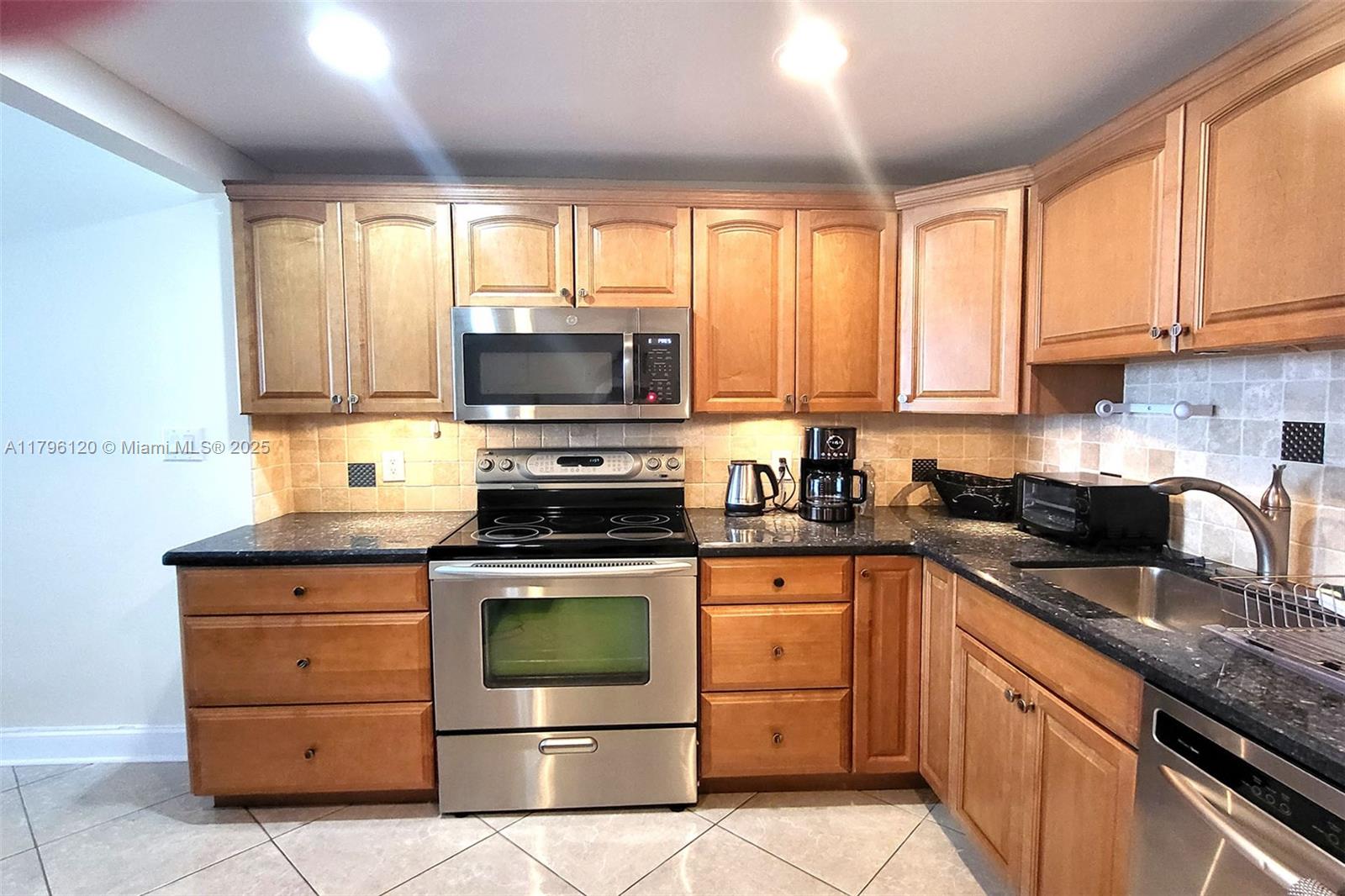 2101 South Ocean Drive, Unit 606 Hollywood, FL 33019 - Photo 4 of 58 a kitchen with granite countertop a sink stainless steel appliances and cabinets
