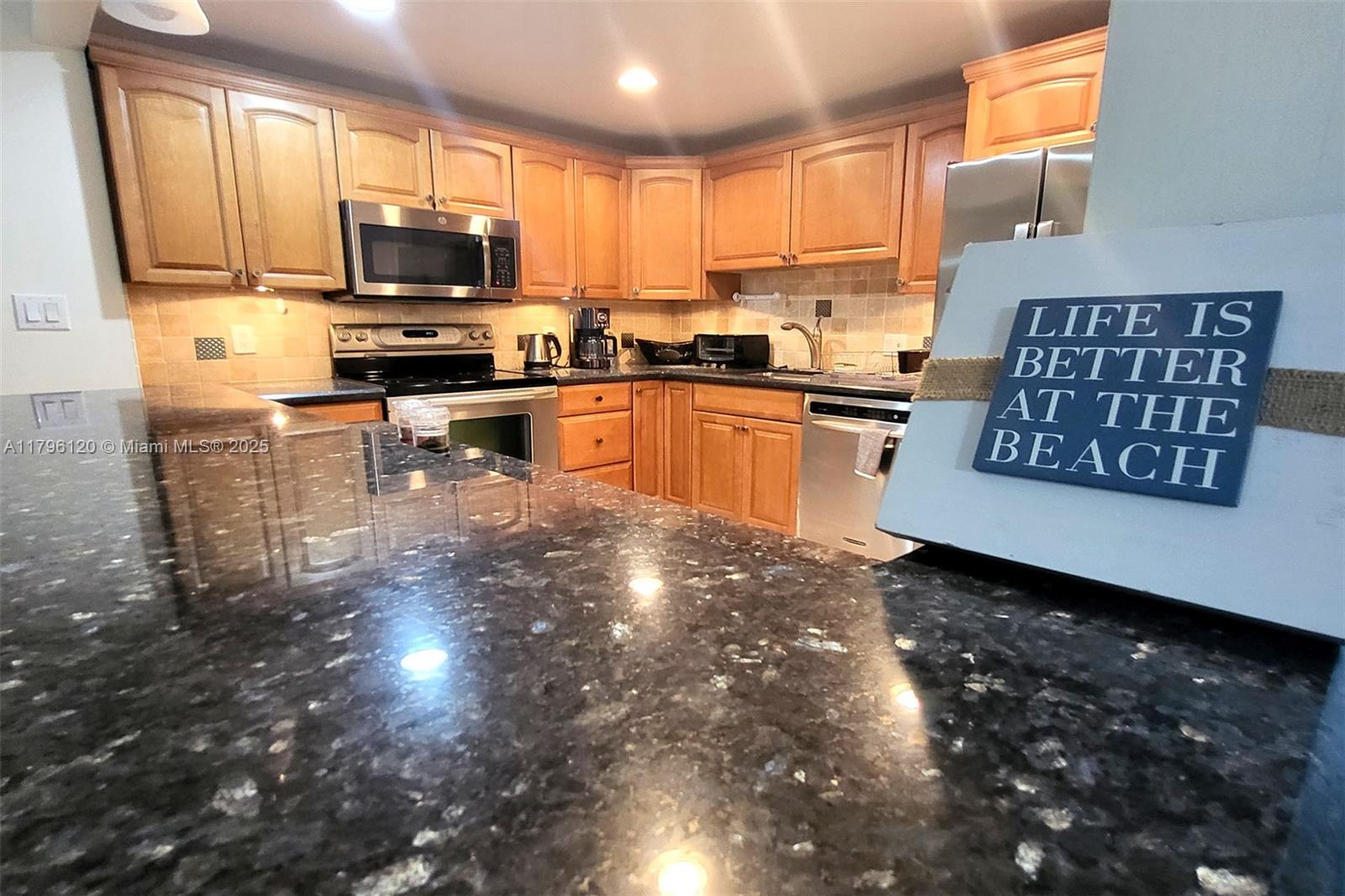 2101 South Ocean Drive, Unit 606 Hollywood, FL 33019 - Photo 10 of 58 a kitchen with stainless steel appliances a sink a stove a microwave a counter top space and cabinets