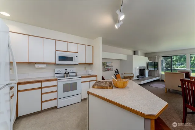 a kitchen with a sink a stove and chairs