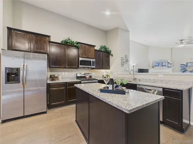 a kitchen with granite countertop stainless steel appliances a sink stove and refrigerator