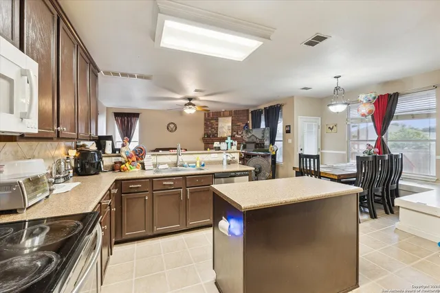 a kitchen with stainless steel appliances granite countertop a stove a sink and a refrigerator