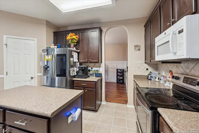 a kitchen with kitchen island granite countertop a sink a counter top space
