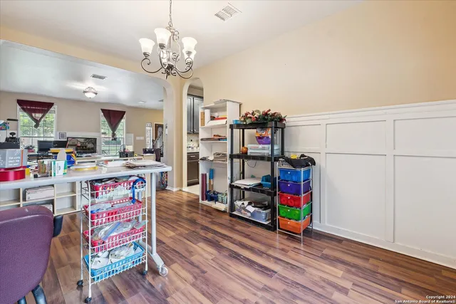 a dining room with furniture a chandelier and wooden floor