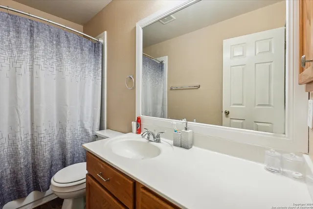 a living room with furniture kitchen view and a wooden floor