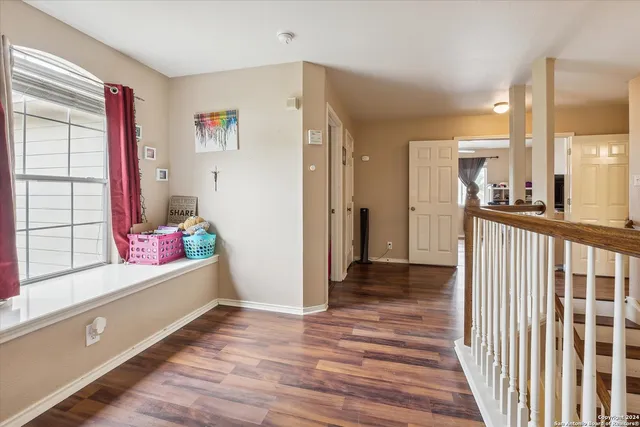 a view of a room with wooden floor closet fan and a window