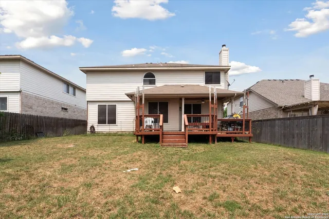 a view of house with backyard and deck