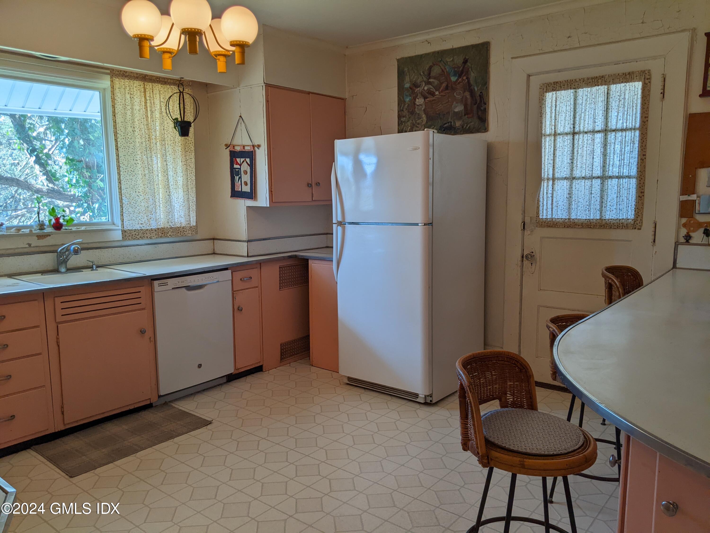 23 Ballwood Road Old Greenwich, CT 06870 - Photo 15 of 27 a kitchen with stainless steel appliances granite countertop a refrigerator a sink a stove and a dining table with wooden floor
