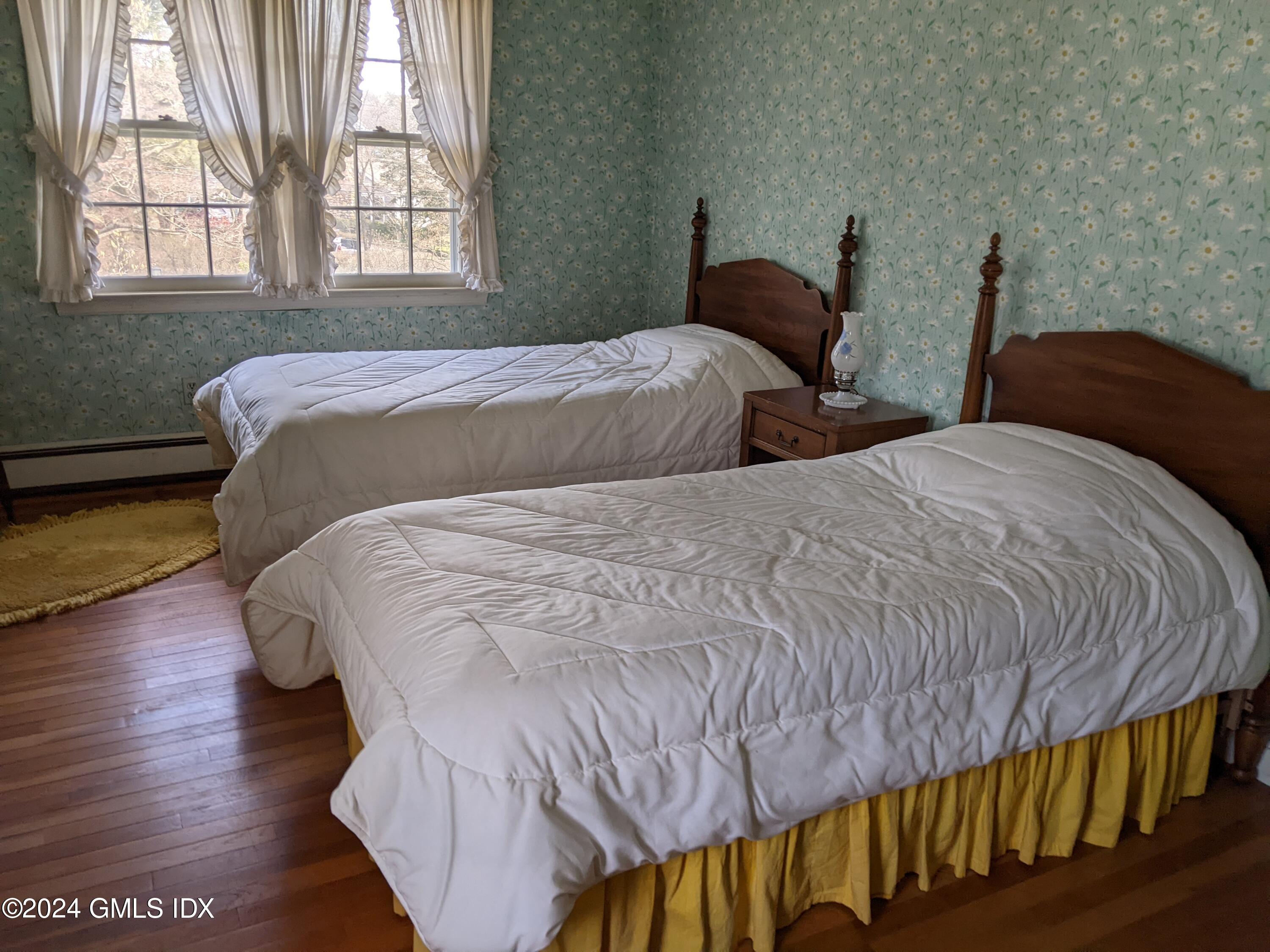 23 Ballwood Road Old Greenwich, CT 06870 - Photo 19 of 27 a bedroom with two beds and wooden floor