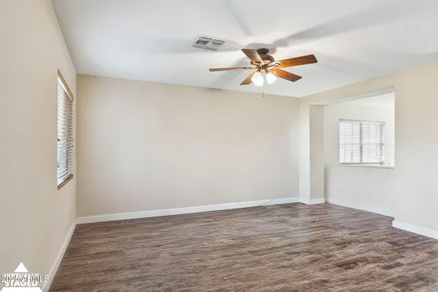 a view of a room with wooden floor and a ceiling fan