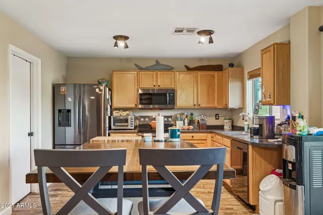 a kitchen with stainless steel appliances granite countertop a stove top oven a sink dishwasher and cabinets with wooden floor