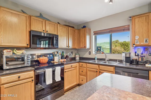 a kitchen with stainless steel appliances a sink cabinets and a window
