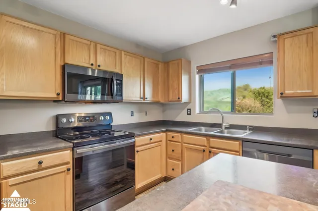 a kitchen with stainless steel appliances a stove sink microwave and cabinets