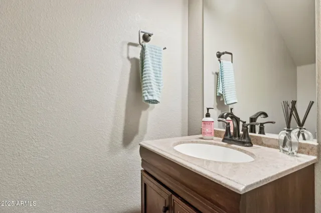 a bedroom with a bed and a lamp on dresser