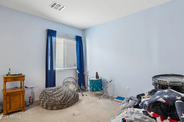 a bedroom with a bed and a painting on the wall