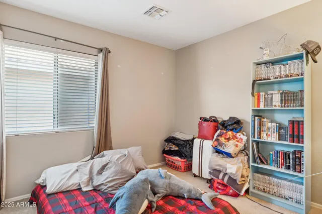 a bedroom with a bed and a painting on the wall