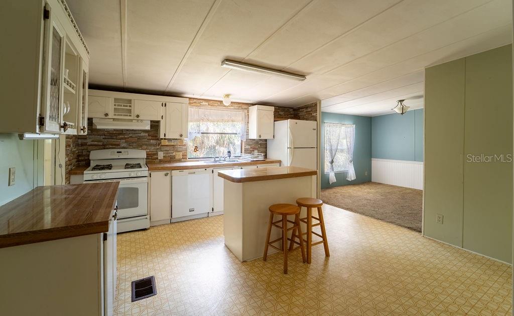 24031 Armadillo Road Astor, FL 32102 - Photo 10 of 43 a kitchen with cabinets and chairs