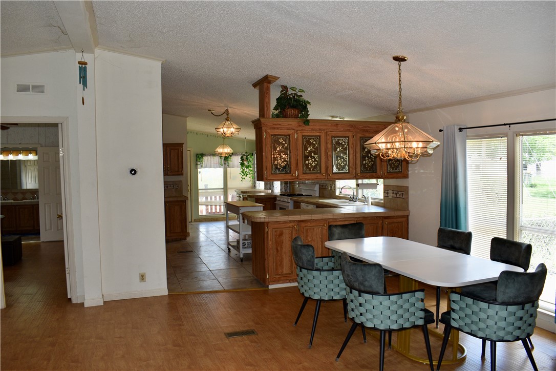 25051 Lake Shore Drive Mathis, TX 78368 - Photo 17 of 40 a dining room with furniture a chandelier and wooden floor