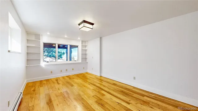 wooden floor in an empty room with a window