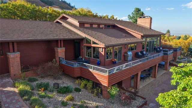 an aerial view of a house with balcony and outdoor seating