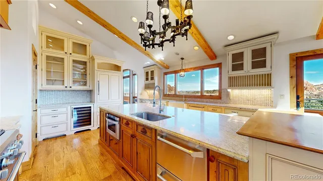 a large kitchen with stainless steel appliances granite countertop a lot of counter space and wooden floors