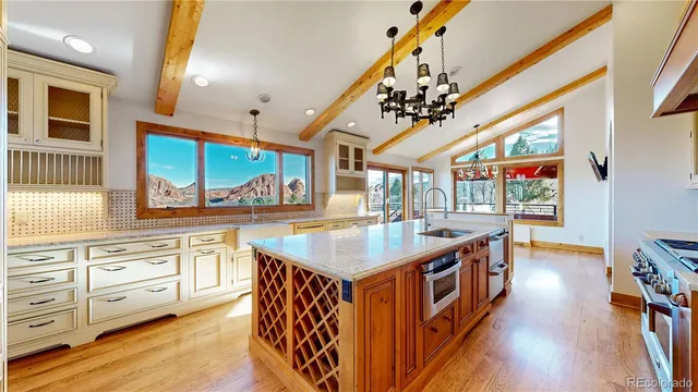 a kitchen with stainless steel appliances granite countertop a lot of counter space and wooden floors