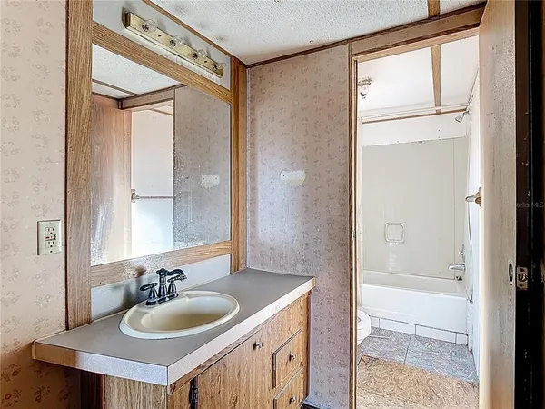 a bathroom with a granite countertop sink a mirror and a shower
