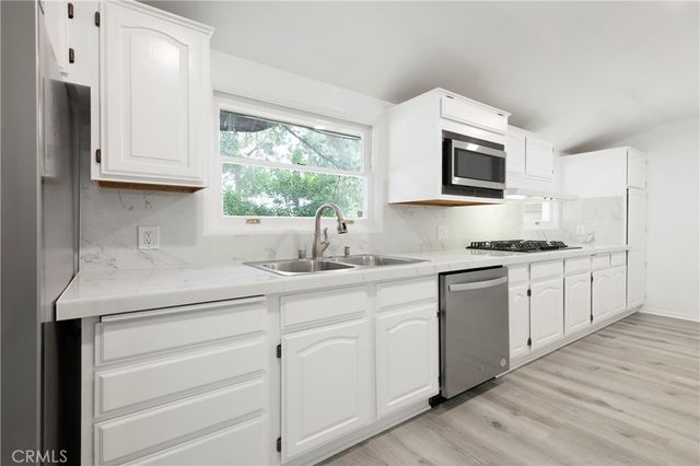 a kitchen with granite countertop white cabinets and white appliances