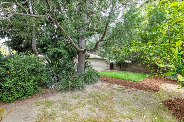 a view of a house with a tree and a yard