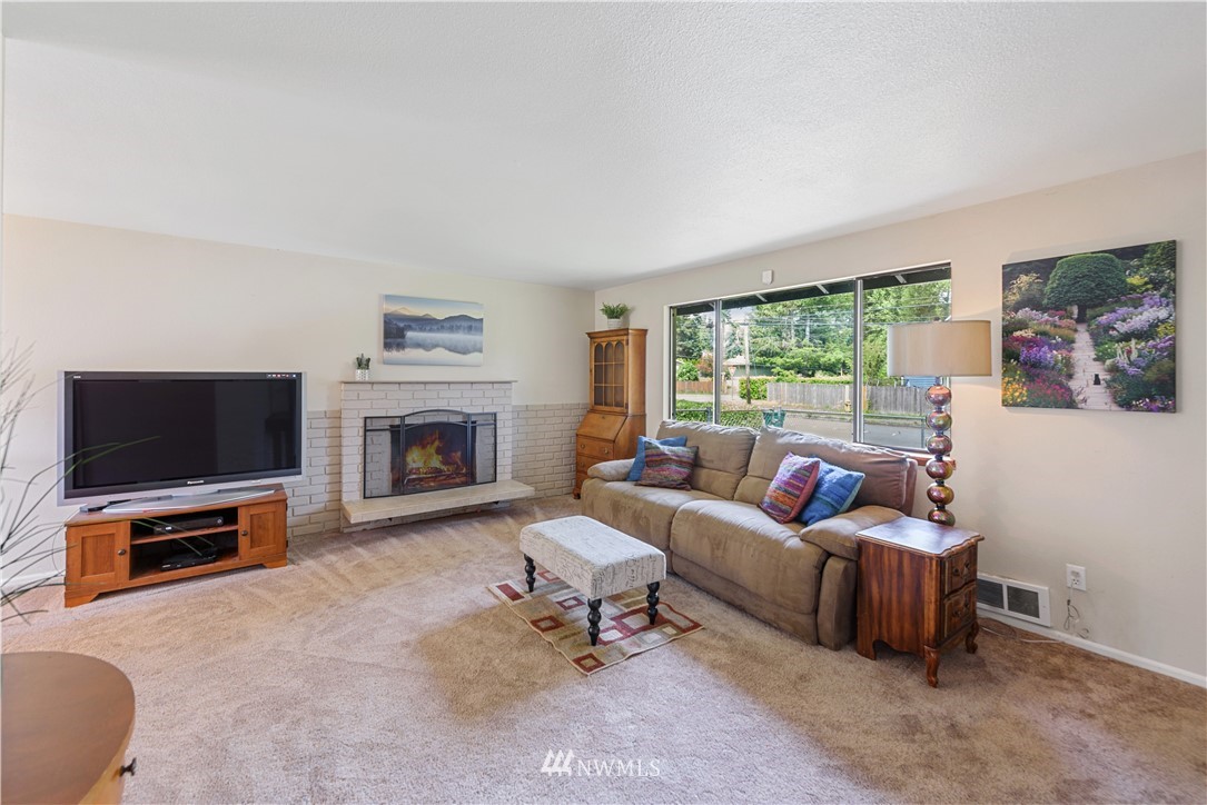 19910 Filbert Drive Bothell, WA 98012 - Photo 4 of 16 a living room with furniture a flat screen tv and a fireplace
