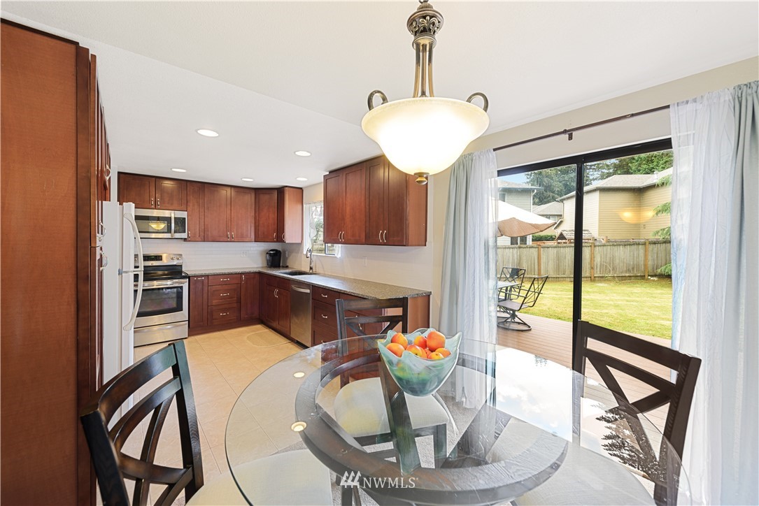 19910 Filbert Drive Bothell, WA 98012 - Photo 6 of 16 a kitchen with stainless steel appliances granite countertop a stove and a dining table with white cabinet