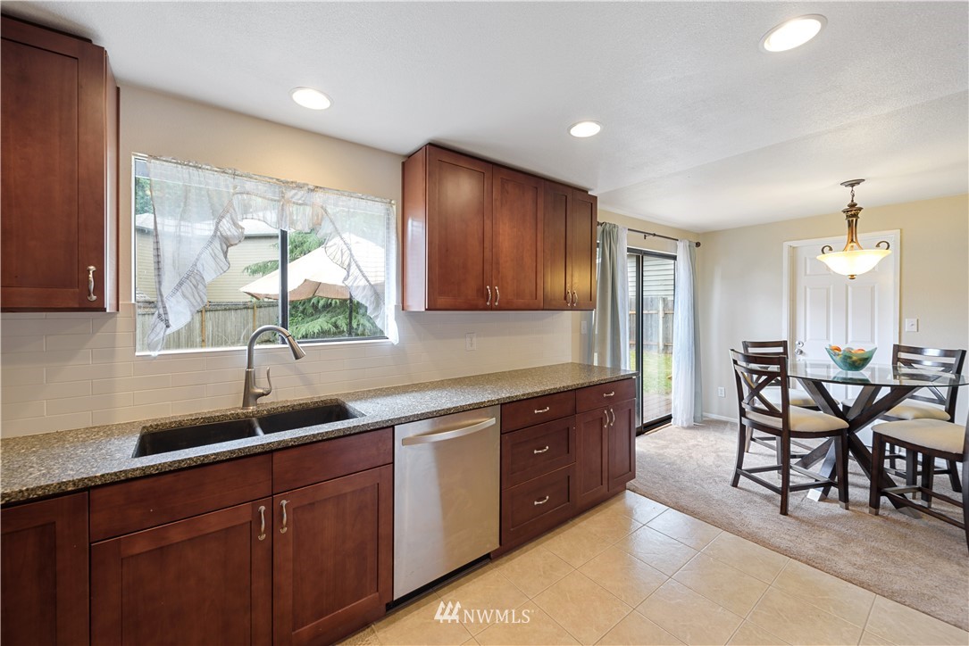 19910 Filbert Drive Bothell, WA 98012 - Photo 7 of 16 a kitchen with granite countertop a sink dining table and chairs