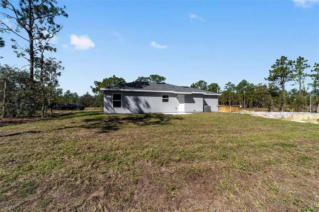 a front view of house with yard and trees around