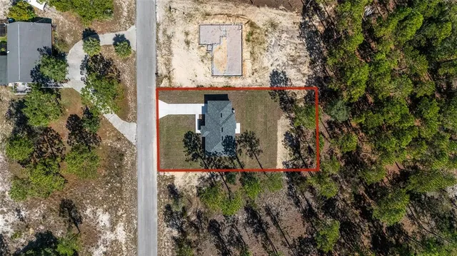a view of a yard with wooden fence