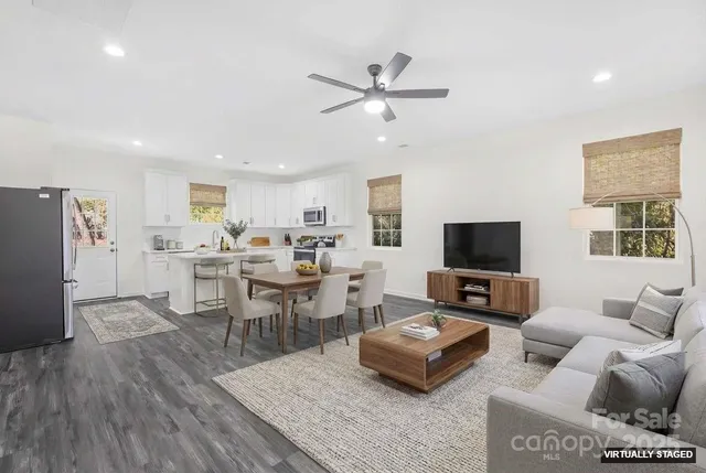 a living room with furniture kitchen view and a window