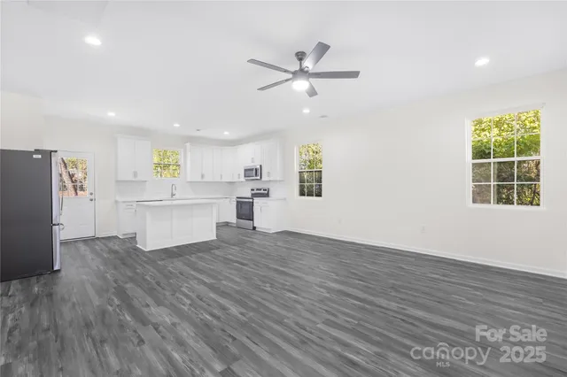 a view of a kitchen with wooden floor a sink and a window