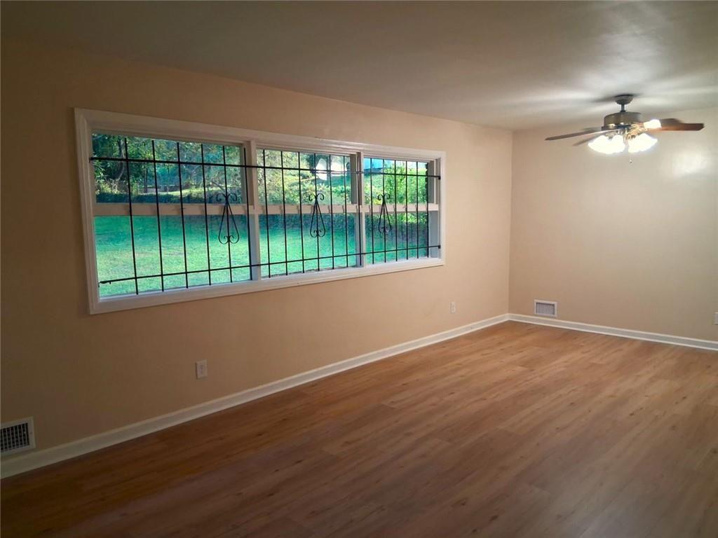 1915 Wee Kirk Road Southeast Atlanta, GA 30316 - Photo 10 of 23 a view of an empty room with wooden floor and a window