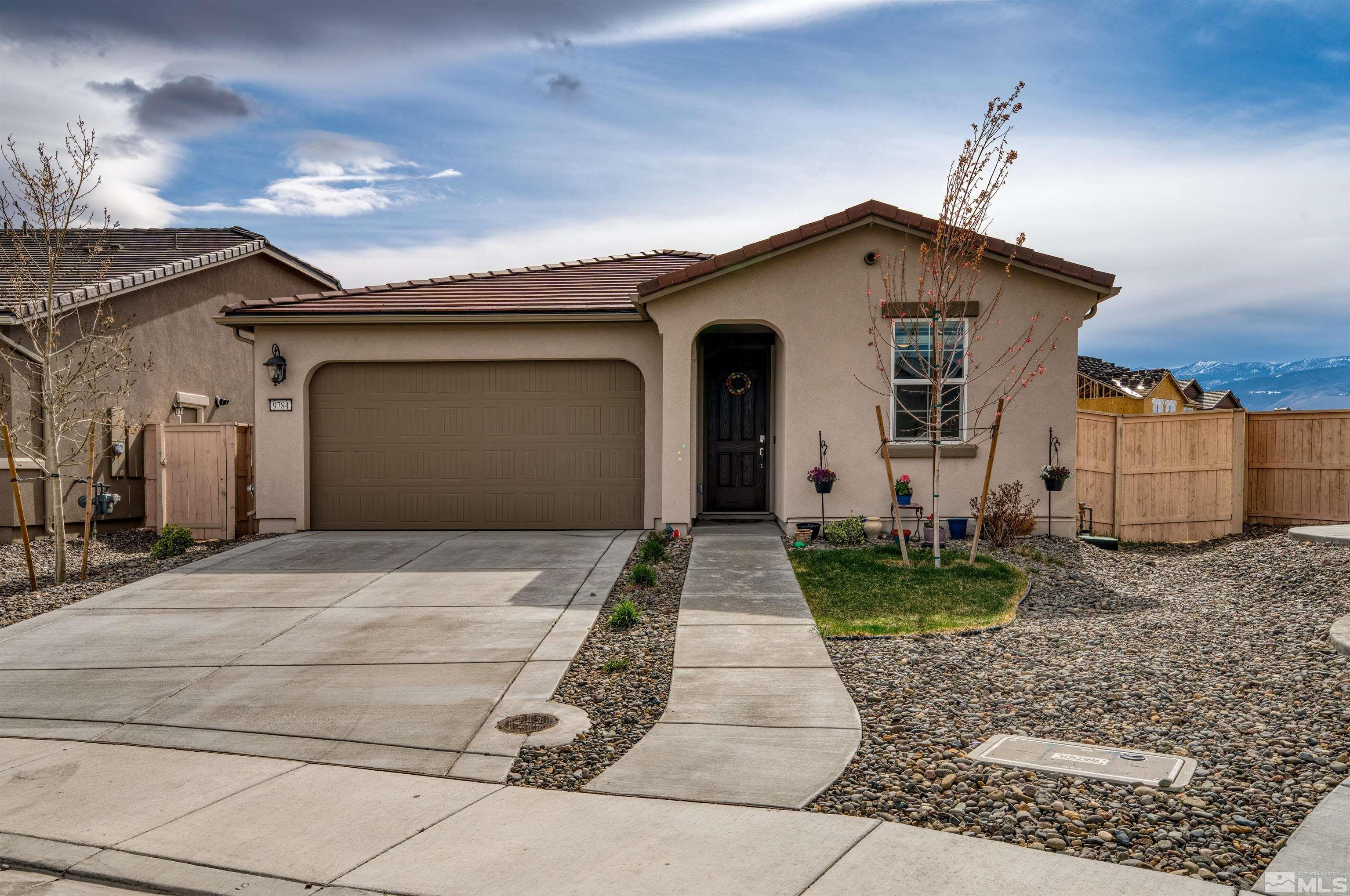 9784 Quartette Drive Reno, NV 89521 - Photo 1 of 18 a front view of a house with garden