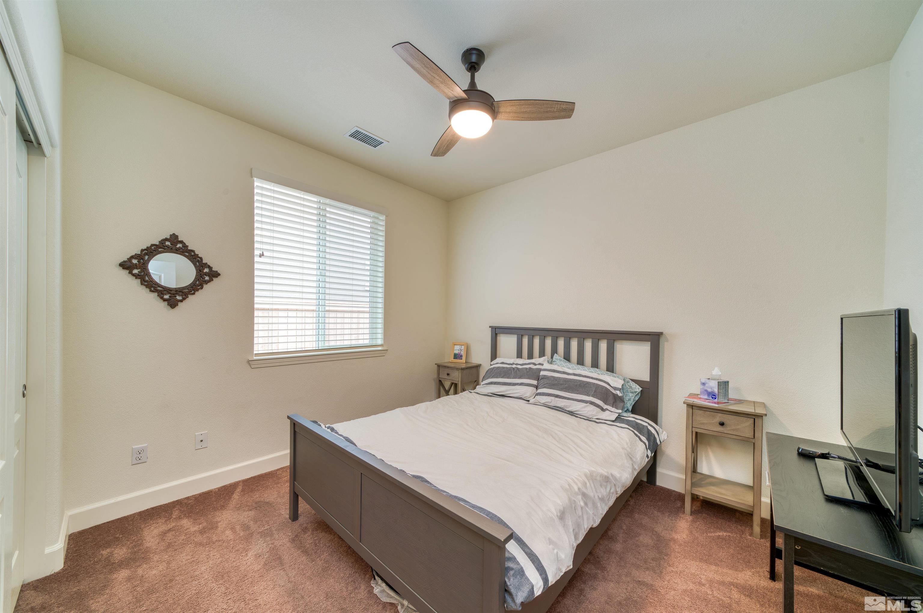 9784 Quartette Drive Reno, NV 89521 - Photo 15 of 18 a bedroom with a bed and a chandelier