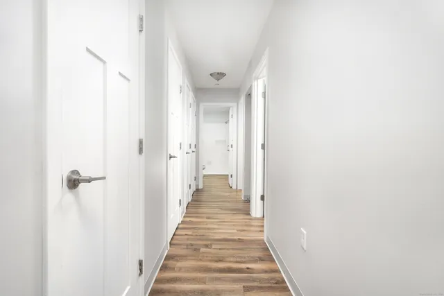 a view of a hallway with wooden floor